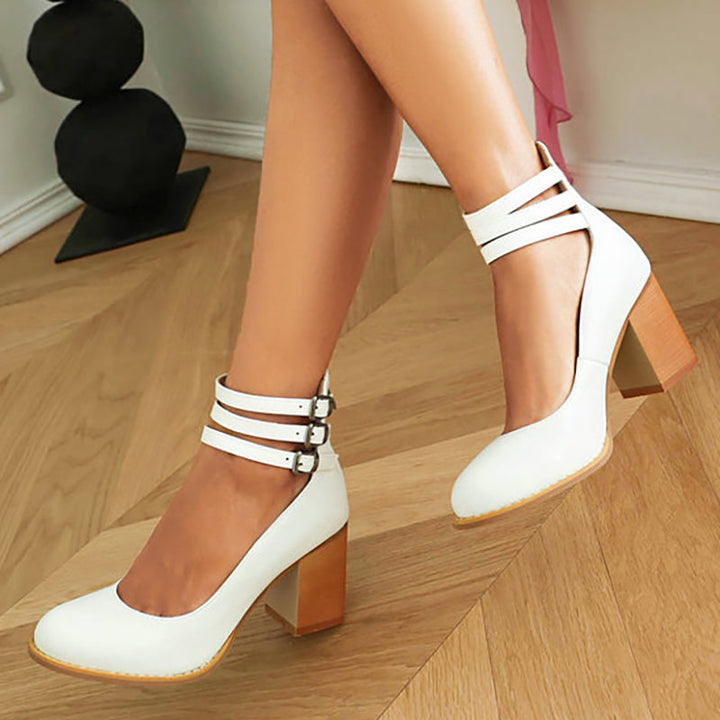 Female wearing refined open toe sandals with a block heel on a plain background.