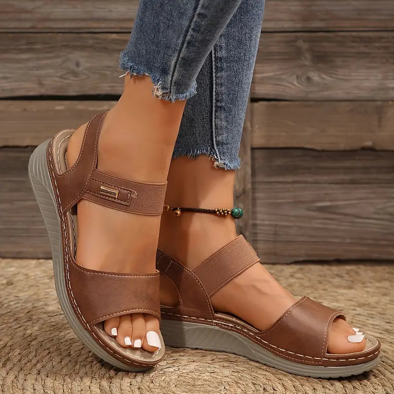 Female modelling open-toe sandals with a comfortable everyday design.