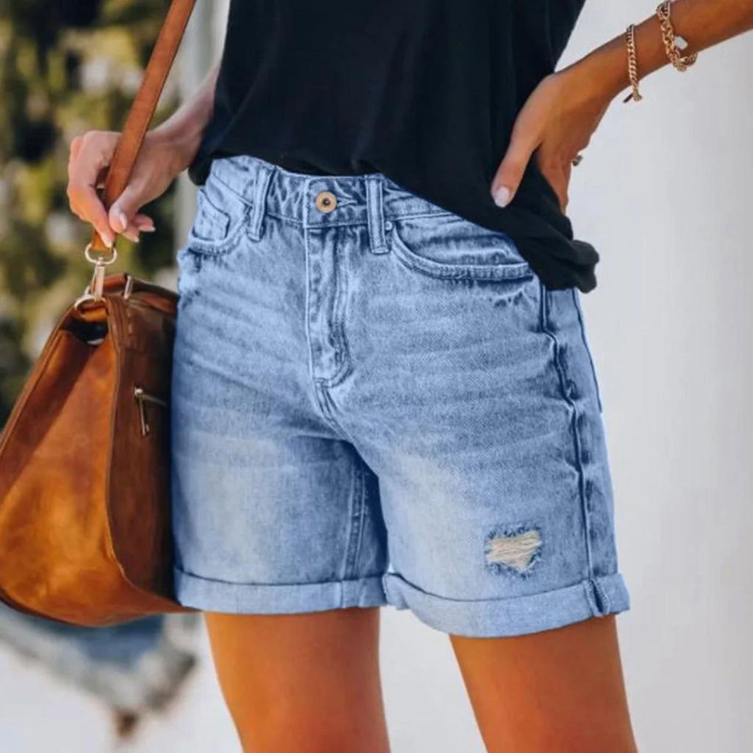 Female model wearing lightweight summer shorts with a high-rise waistband on a plain backdrop.