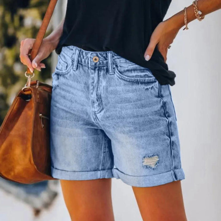 Female model wearing lightweight summer shorts with a high-rise waistband on a plain backdrop.