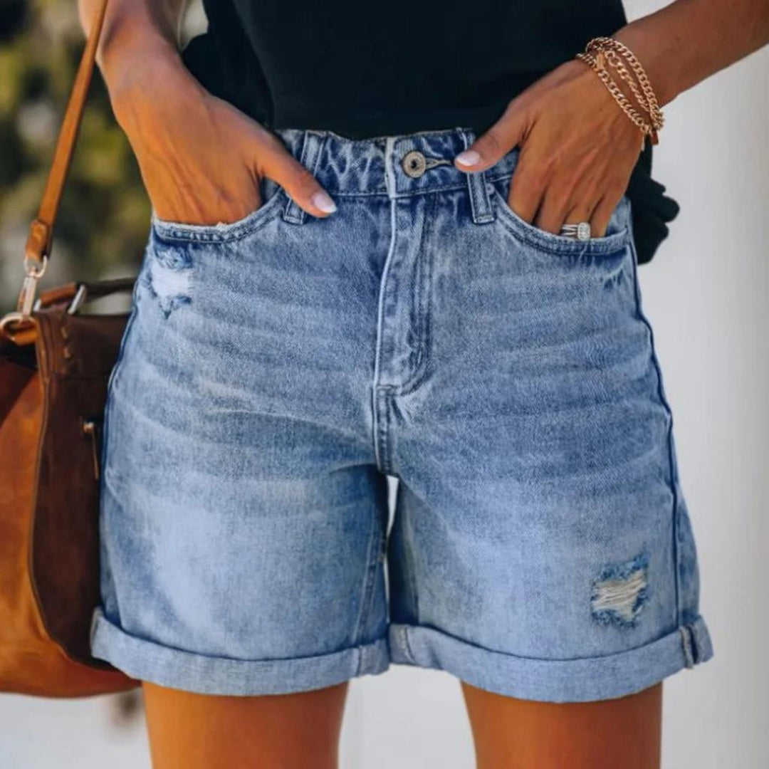 Female model wearing high waist ladies shorts on a plain background.