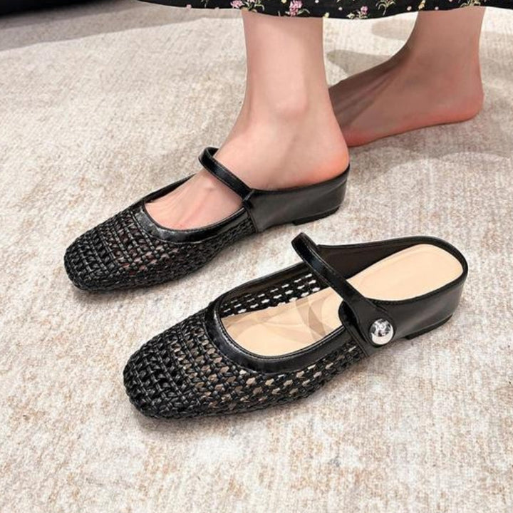 Female model wearing metallic woven flat mule shoes on a plain background.