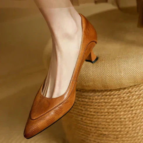 Female model wearing textured side kitten heels on a plain background.