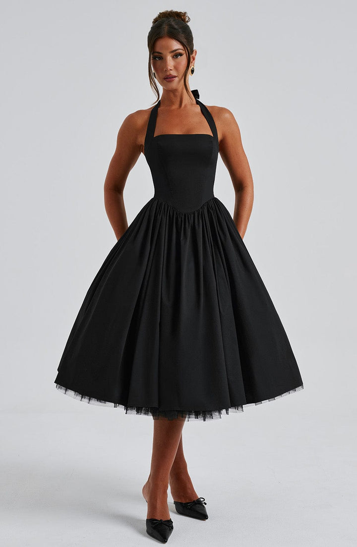Female model wearing a structured neckline midi dress on a plain background.