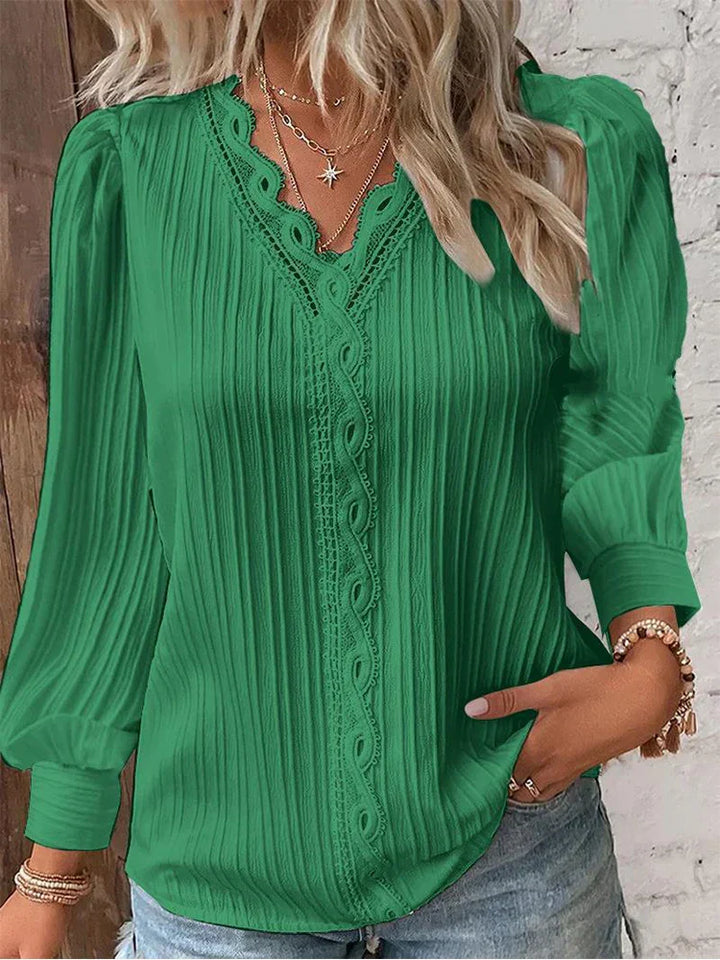  Woman in a relaxed fit blouse featuring lace detailing and long sleeves.