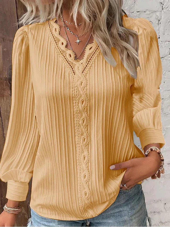 Woman wearing a chiffon blouse with delicate lace features and soft drape.