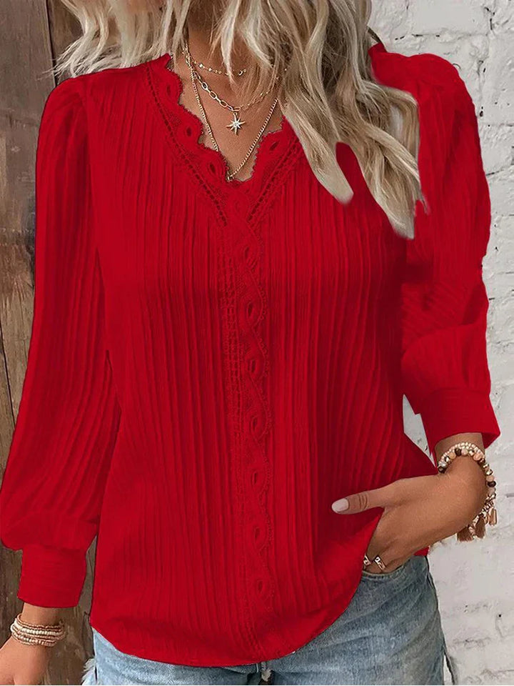  Woman modelling a casual blouse with lace detail and flowing silhouette.