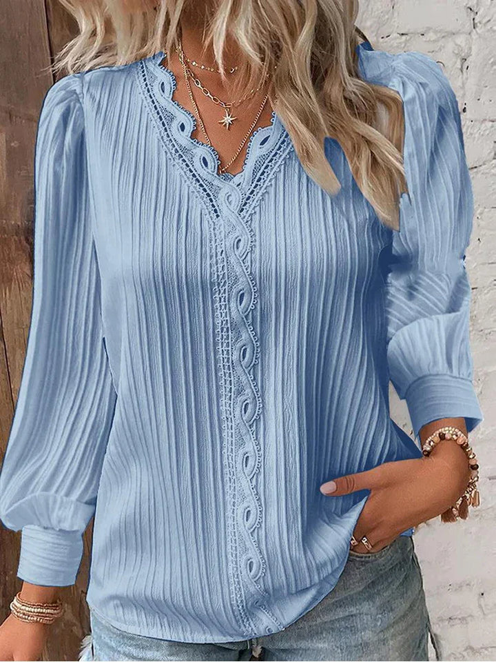 Female modelling a lightweight blouse with decorative lace trim.