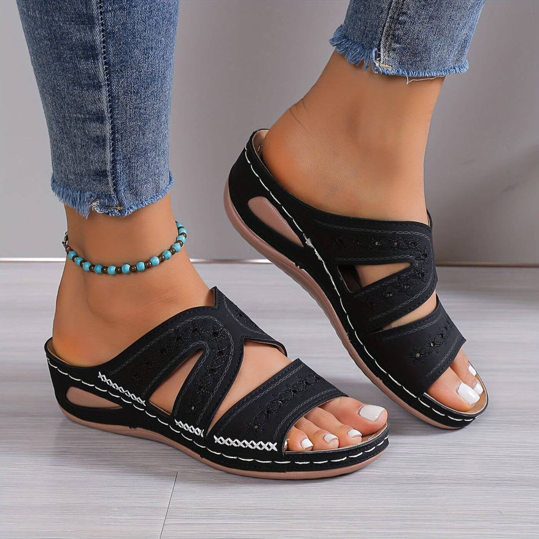 Female modelling lightweight walking sandals with textured soles.