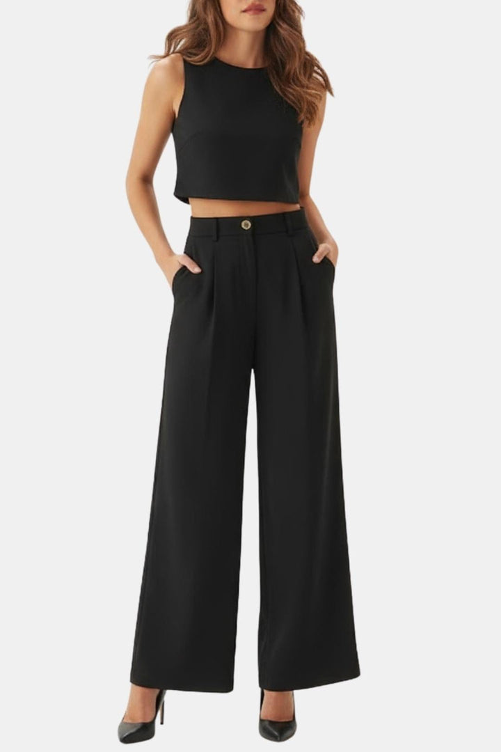 Female model wearing a sleeveless crop top and wide-leg pants set against a plain background.