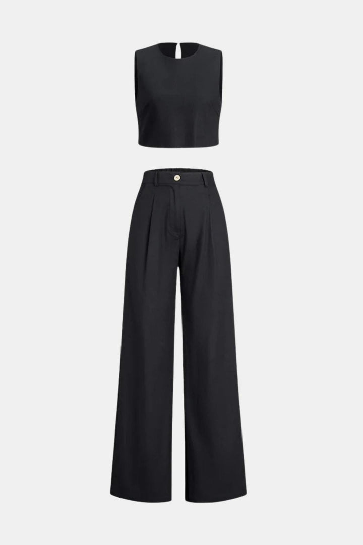 Woman in a boho two-piece pants outfit with a cropped top on a plain background.