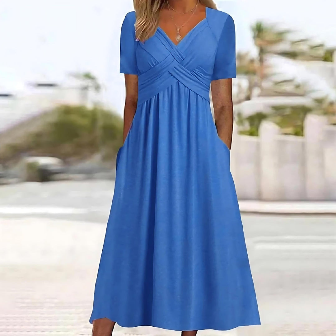 Woman wearing a midi dress with short sleeves on a plain background.
