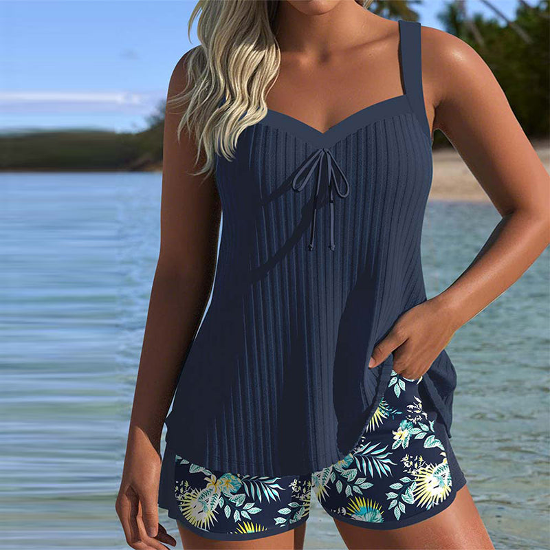 Model wearing a striped tankini set with beach shorts