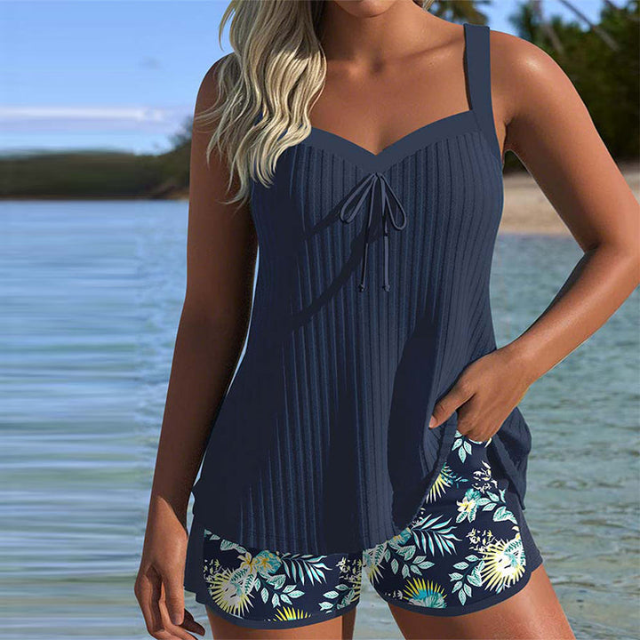 Model wearing a striped tankini set with beach shorts