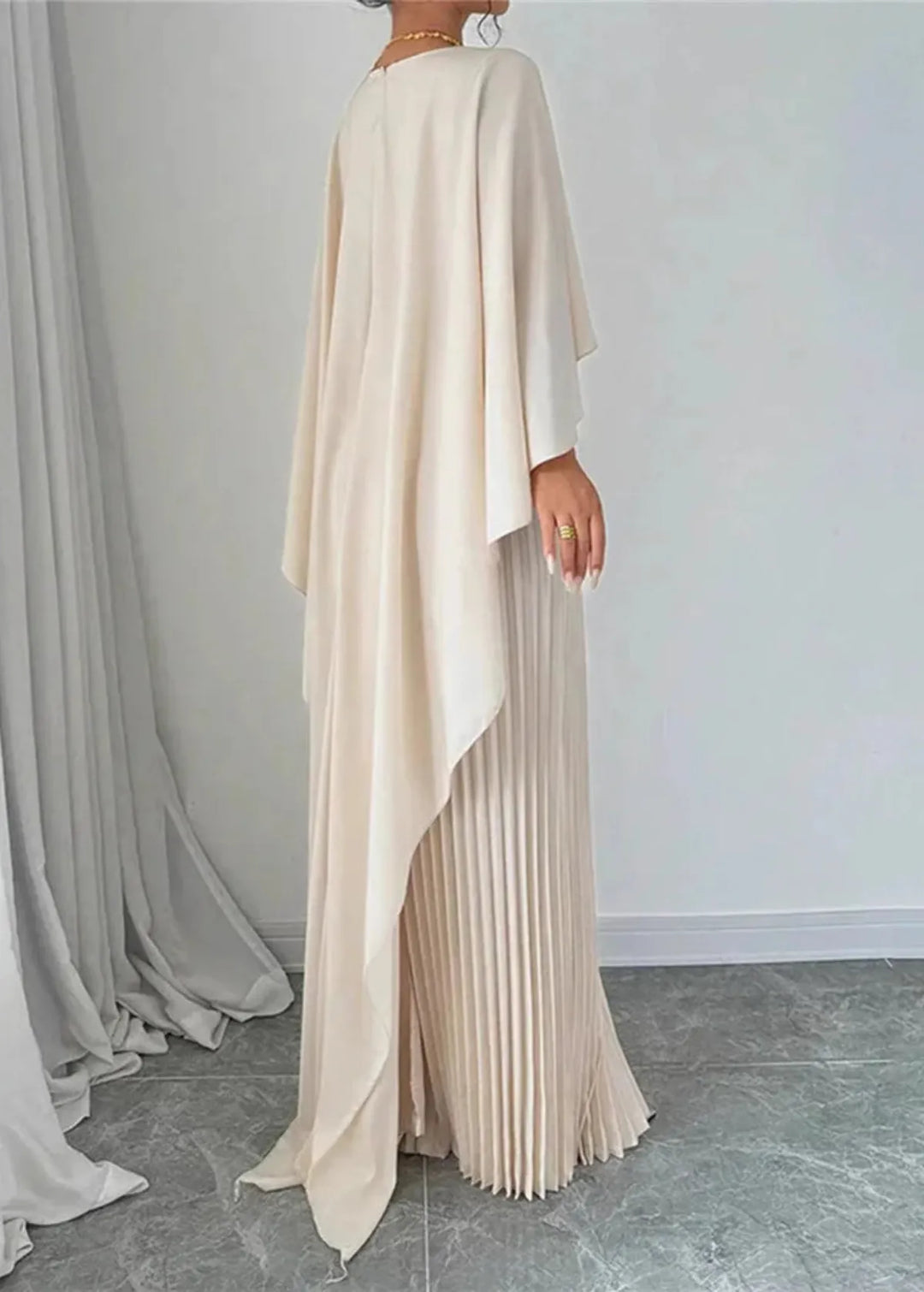 Female model in a full-length pleated occasion dress against a plain background.