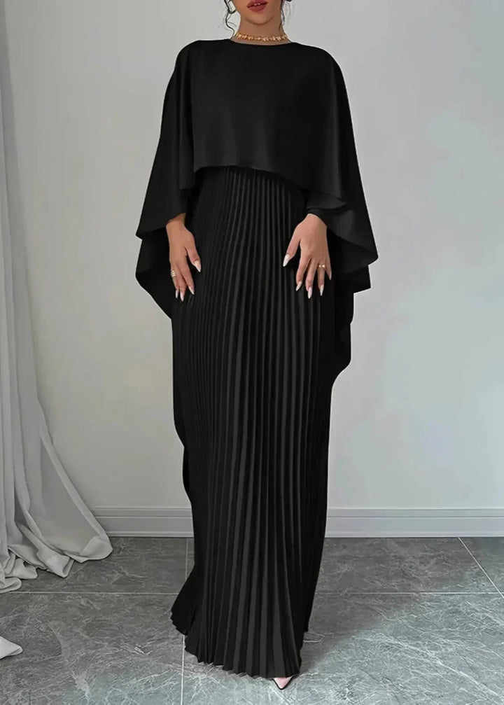 Female model in a long event dress with soft pleats on a plain background.