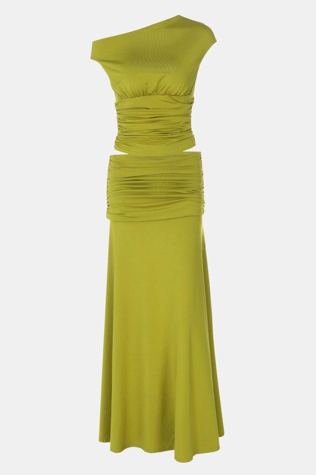 Model wearing a green two piece maxi skirt outfit with one shoulder styling on a plain background.