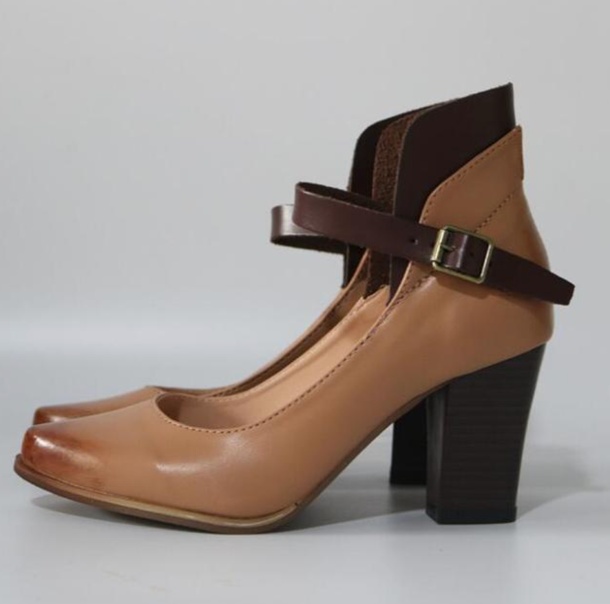 Female standing in chic strappy heel sandals on a plain background.