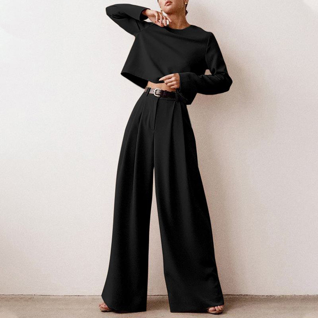 Woman wearing a coordinated two-piece outfit with wide-leg cropped trousers on a plain background.