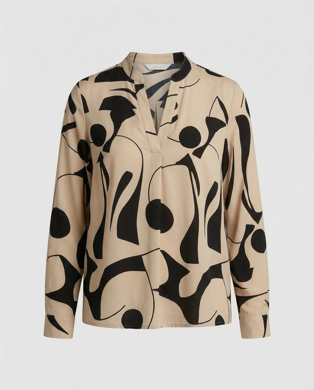 Versatile blouse paired with casual styling on a plain background.