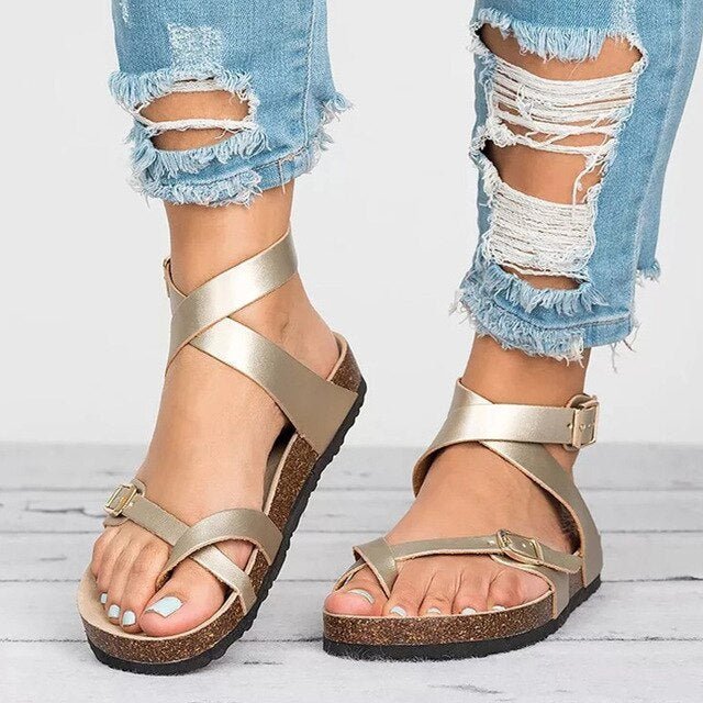 Woman showing everyday summer sandals with a soft footbed on a plain background.
