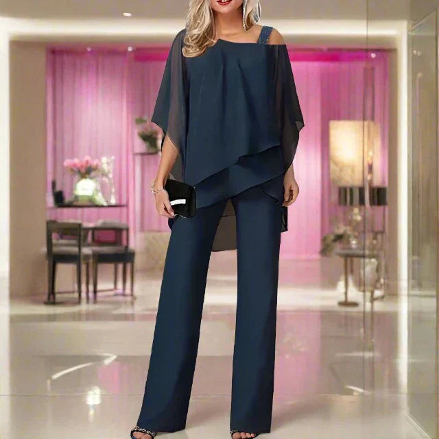 Woman in a relaxed chiffon co-ord set with asymmetric overlay detail.