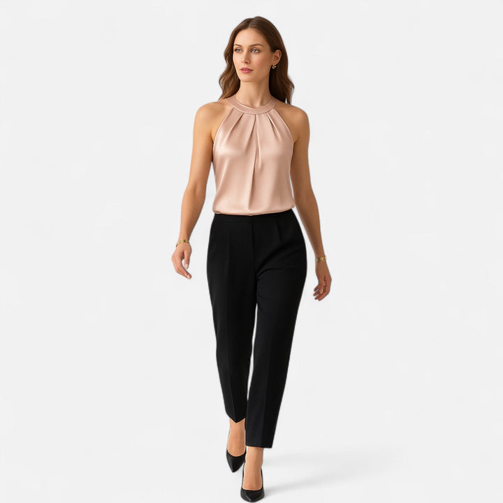 Female model wearing a high neckline draped tank on a plain background.