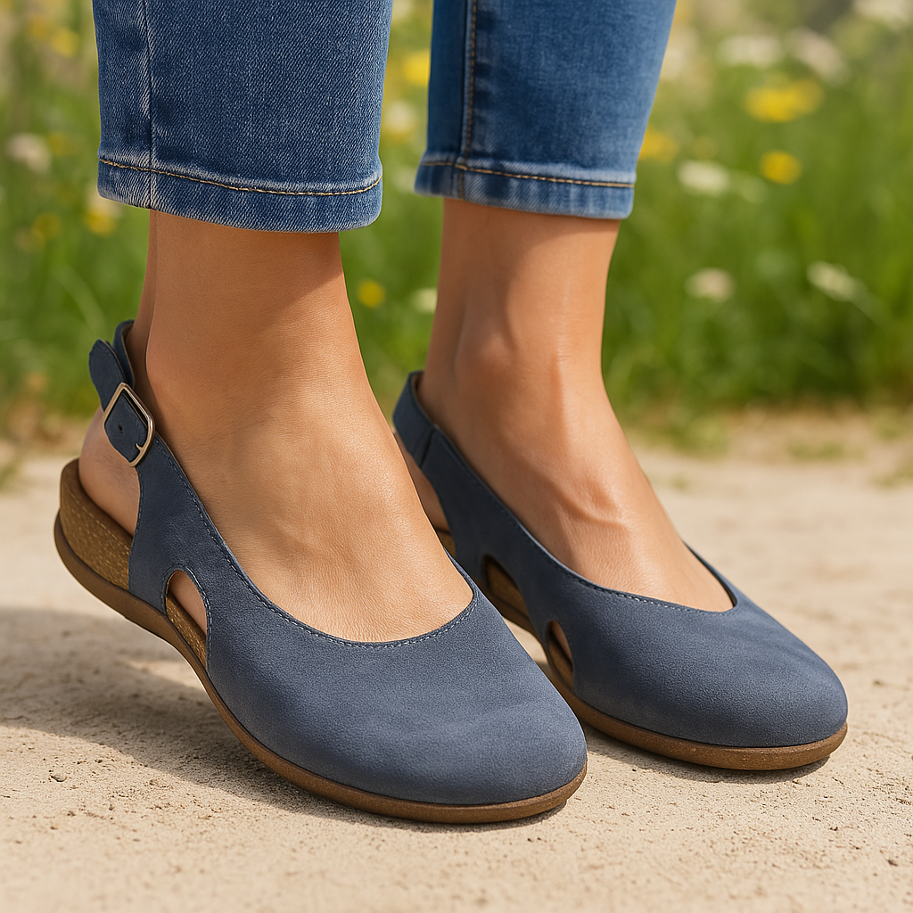 Woman wearing open toe sandals on a plain background.