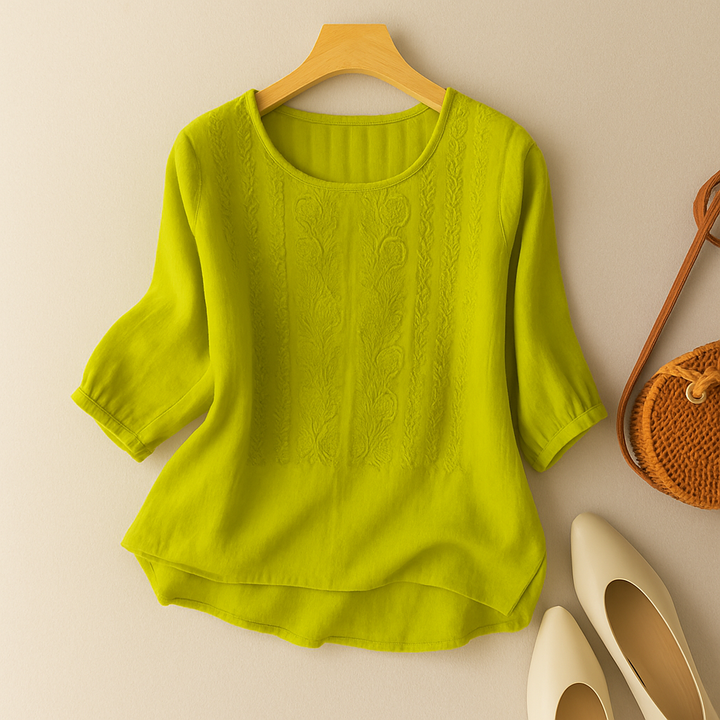 Embroidered warm-weather blouse with short sleeves against a plain background.