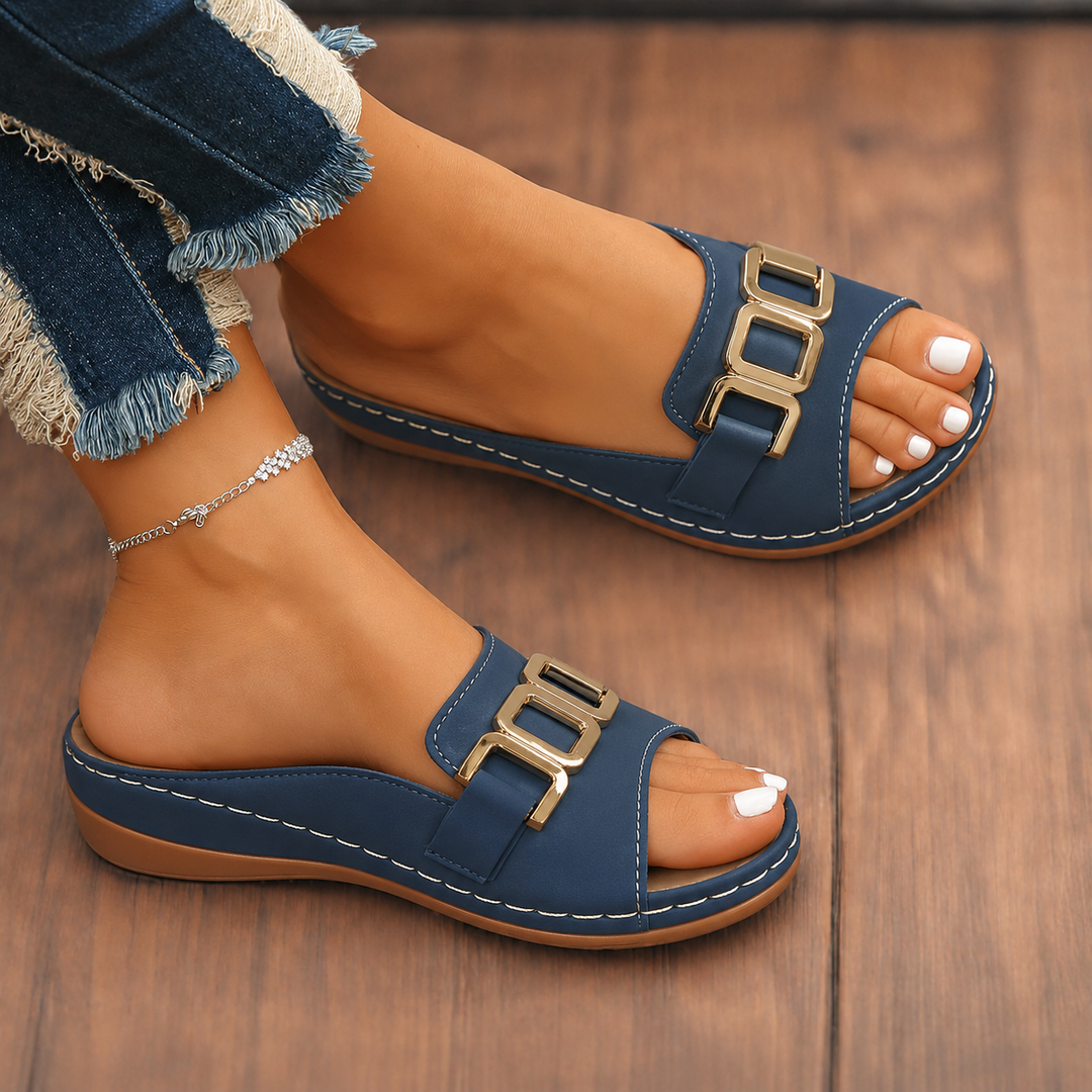 Woman showcasing cushioned buckle sandals against a plain background.