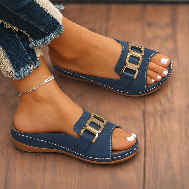 Woman showcasing cushioned buckle sandals against a plain background.