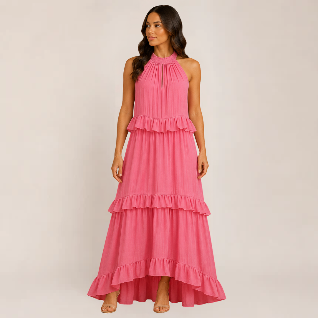 Model in a flowy summer maxi dress with spaghetti straps on a plain background.