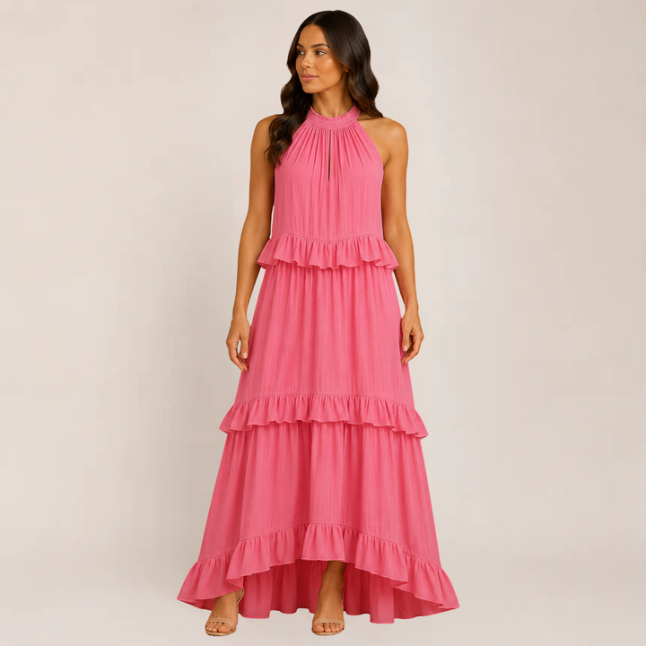 Model in a flowy summer maxi dress with spaghetti straps on a plain background.