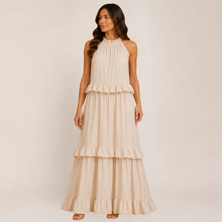 Woman wearing a sleeveless ruffle maxi dress on a plain background.
