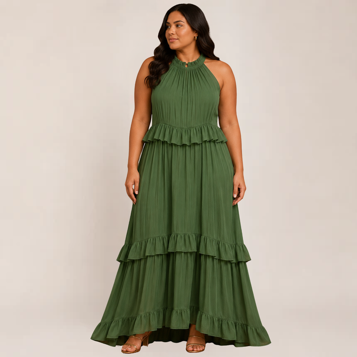 Female model in a breezy maxi dress with soft tiered details on a plain background.