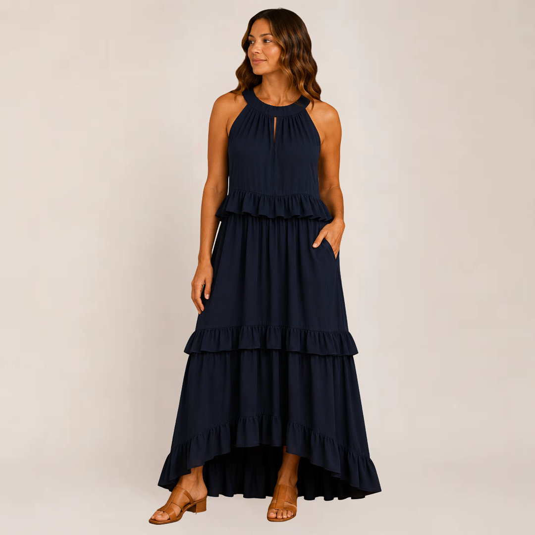 Woman in a lightweight maxi dress with layered ruffles on a plain background.