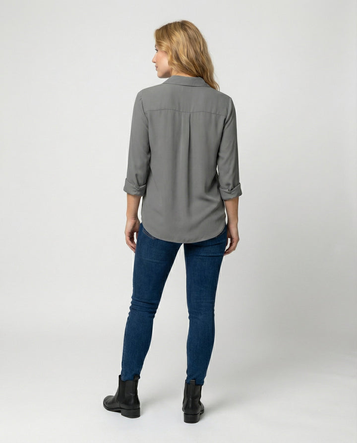 Woman in a soft long sleeve blouse with a timeless collared design.