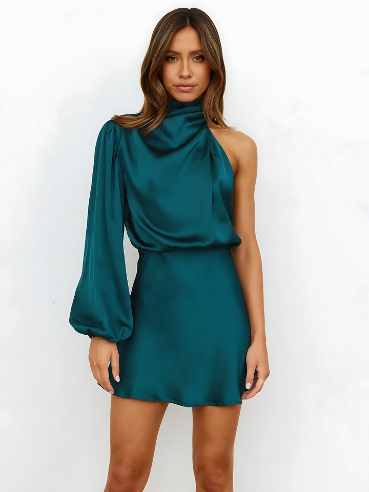 Woman modelling an elegant one-shoulder dress on a plain background.