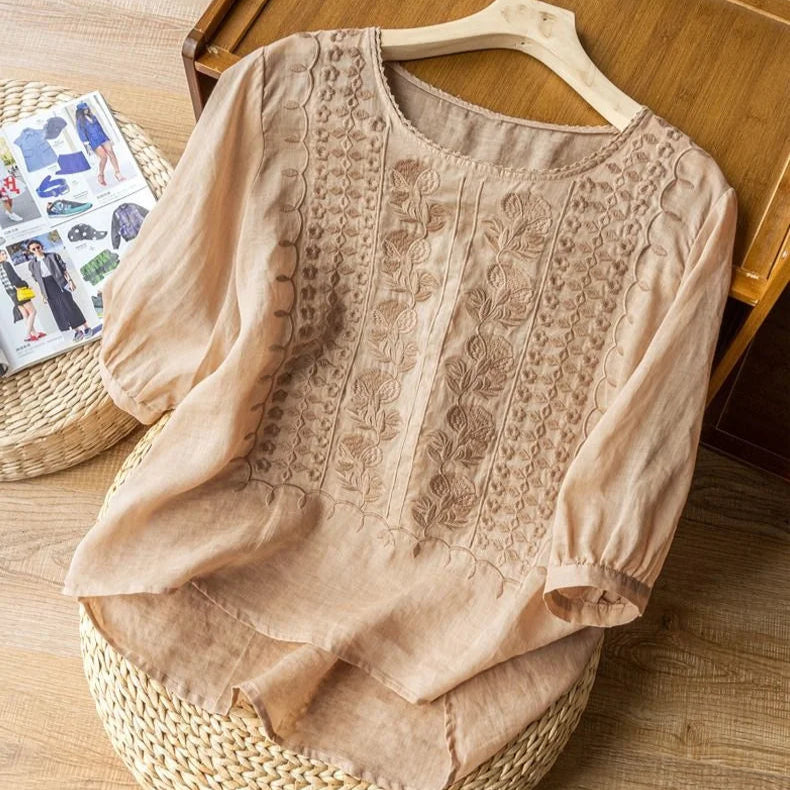 A lightweight embroidered blouse with a relaxed fit on a plain background.