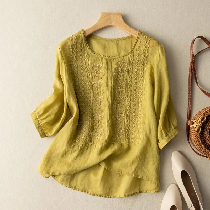 An elegant embroidered top with long cuffed sleeves and a flowing silhouette.