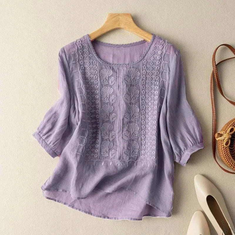 Woman wearing a polished embroidered top for everyday styling on a plain background.