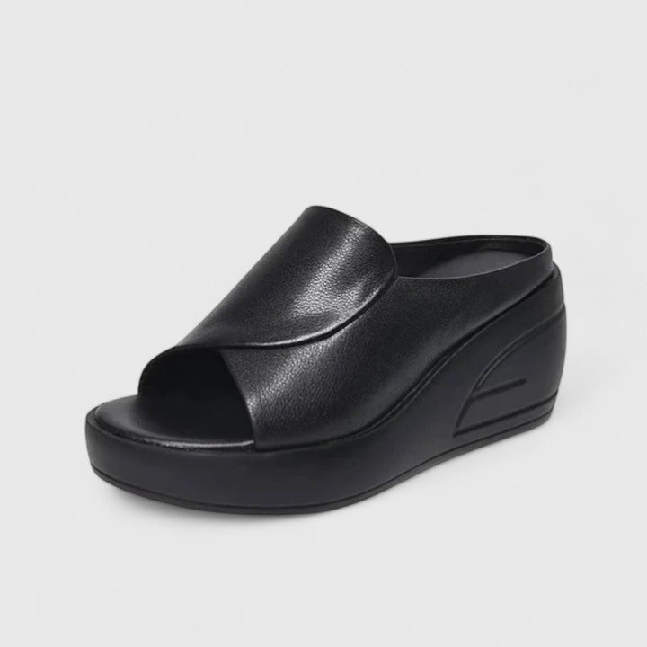 Summer wedge sandals with a simple outfit on a plain background.