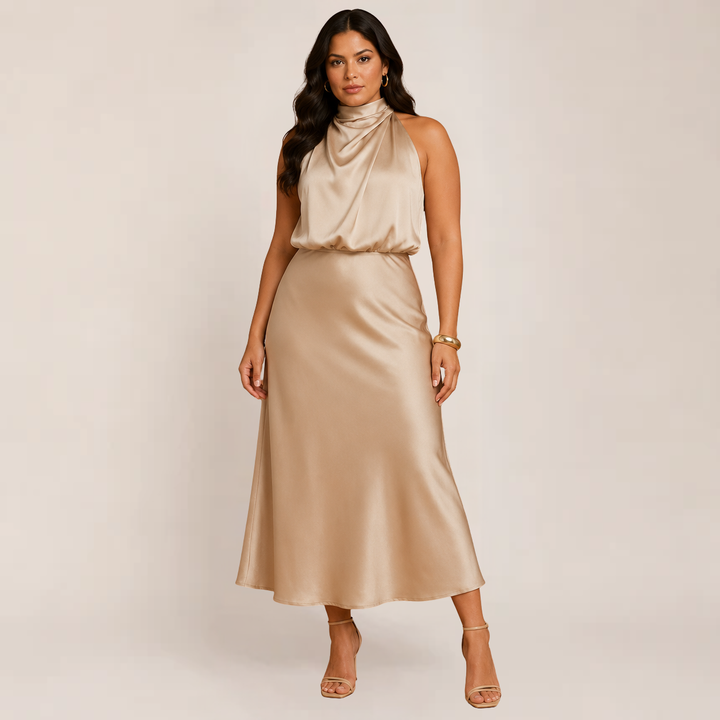 Woman wearing a beige halter evening dress with a flowing A-line shape on a plain background.