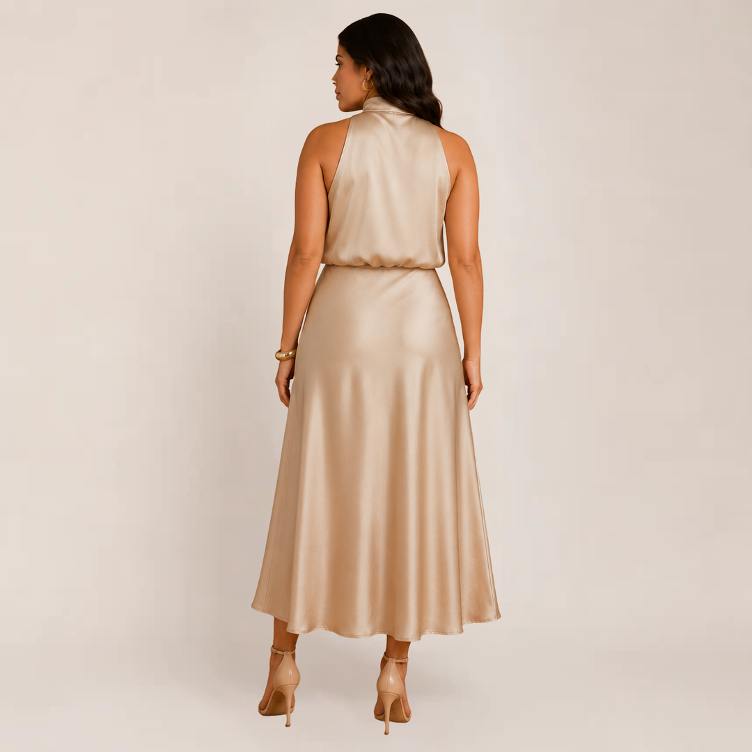 Model wearing a beige A-line evening dress with a shoulder-framing neckline on a plain background.