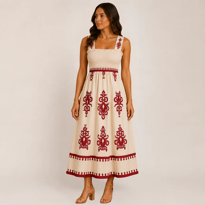 Model in a flowy ankle-length sleeveless dress on a plain background.