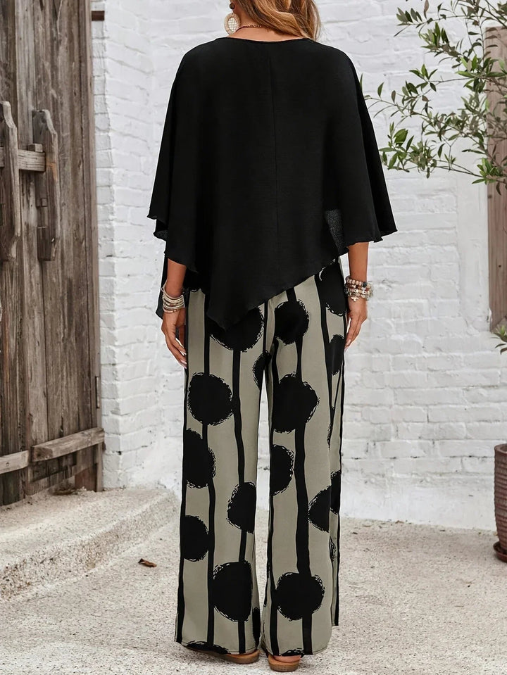 Model wearing a stylish two piece top and printed pants set on a plain background.