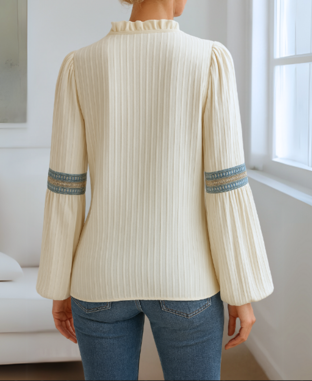 Model wearing a relaxed women’s blouse with vintage-inspired styling on a plain background.