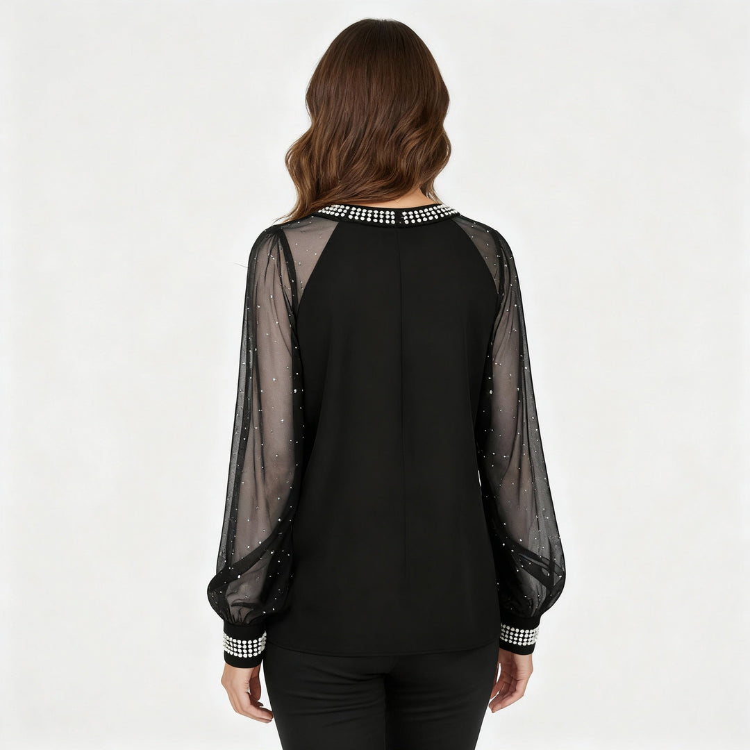 Woman in a soft mesh long sleeve top with sparkling embellishments.