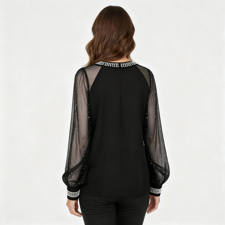 Woman in a soft mesh long sleeve top with sparkling embellishments.