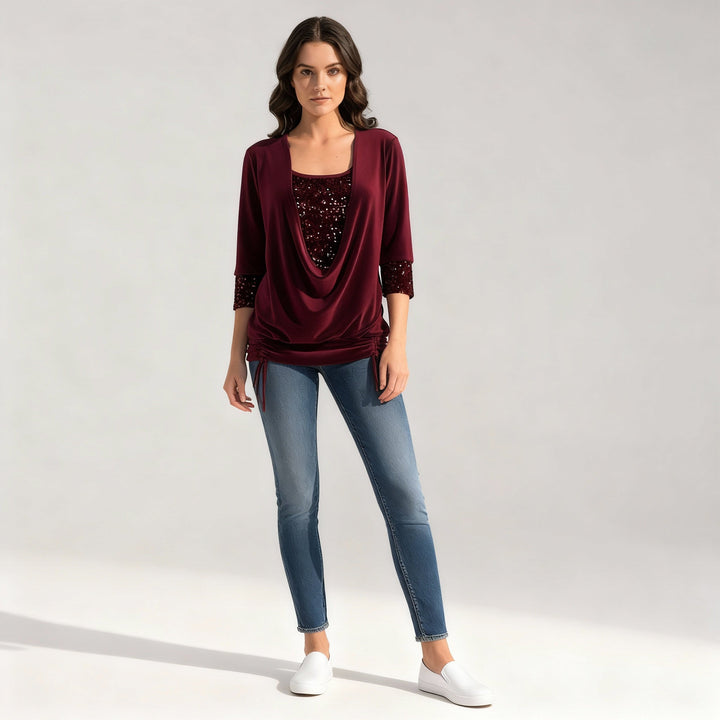Woman in a long-sleeved blouse with elegant sequin accents.